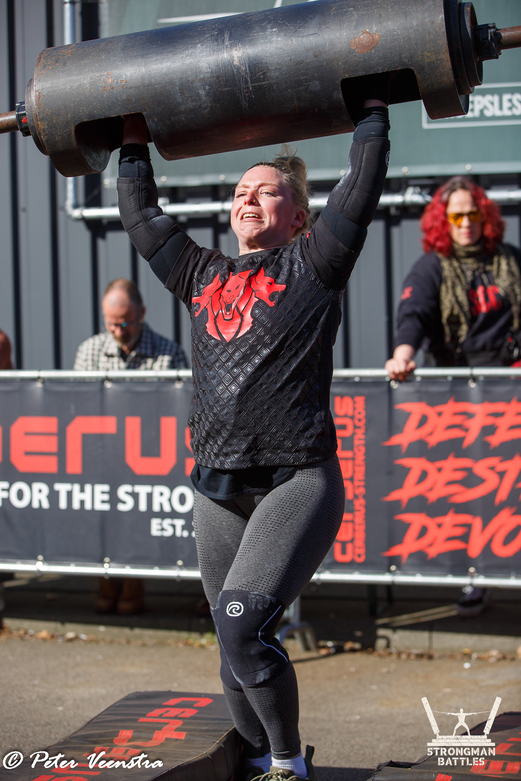 An athlete pressing a log overhead at Natural Strongman in 2025