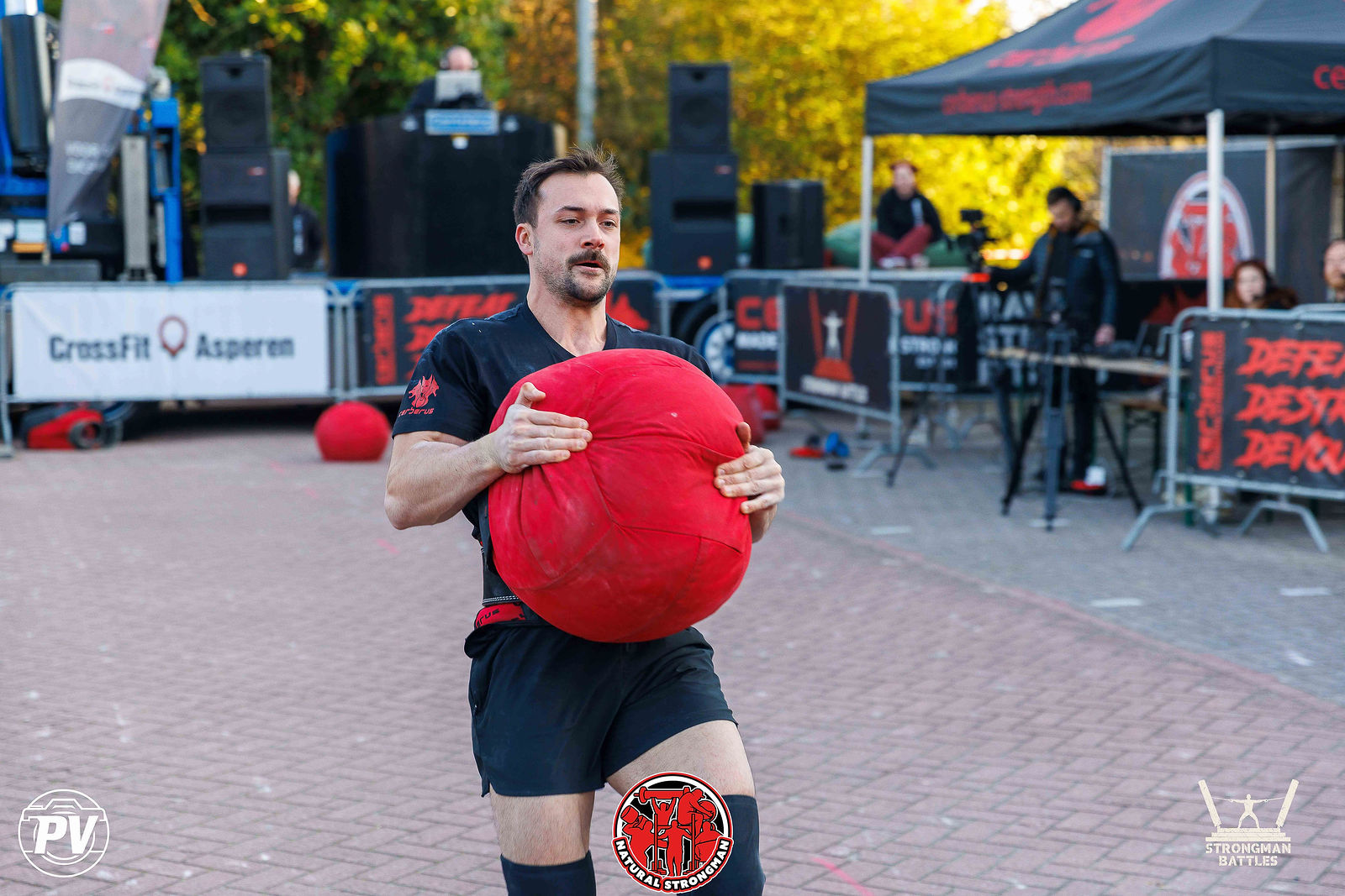 An athlete carrying a red sandbag during a competition in Asperen in 2026.