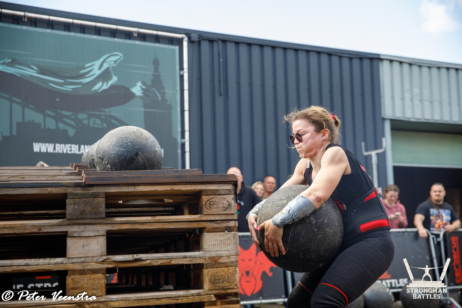 An athlete lifting an Atlas stone at Natural Strongman in 2025