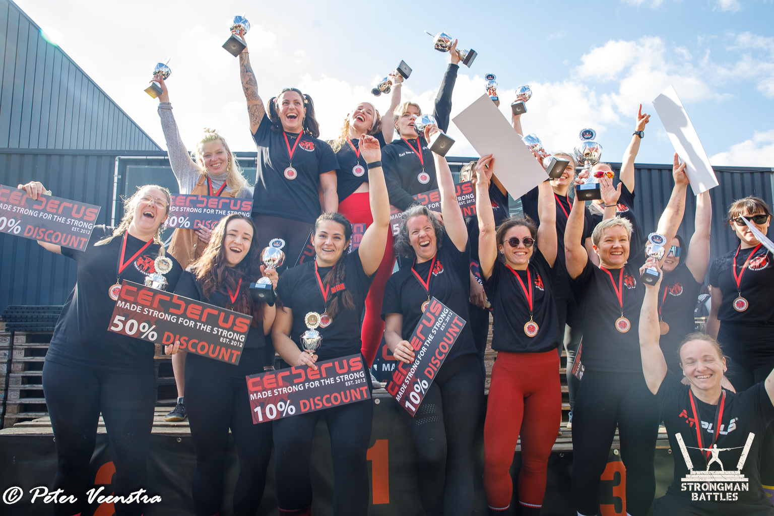 Athletes celebrating together with medals and trophies at the Natural Strongman Battles awards ceremony at Riverland, Nijmegen